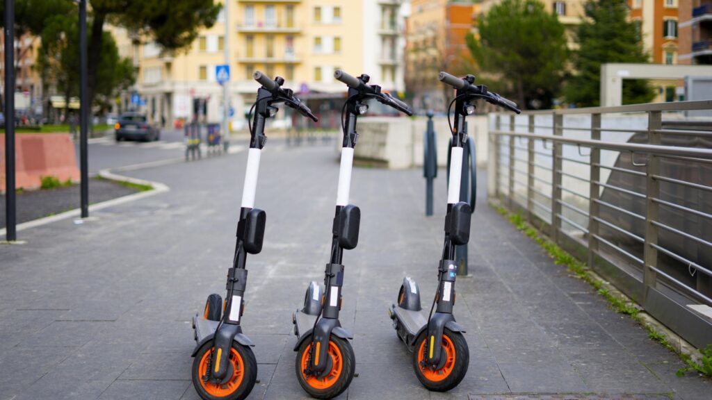 3 knee scooters are parked on the road